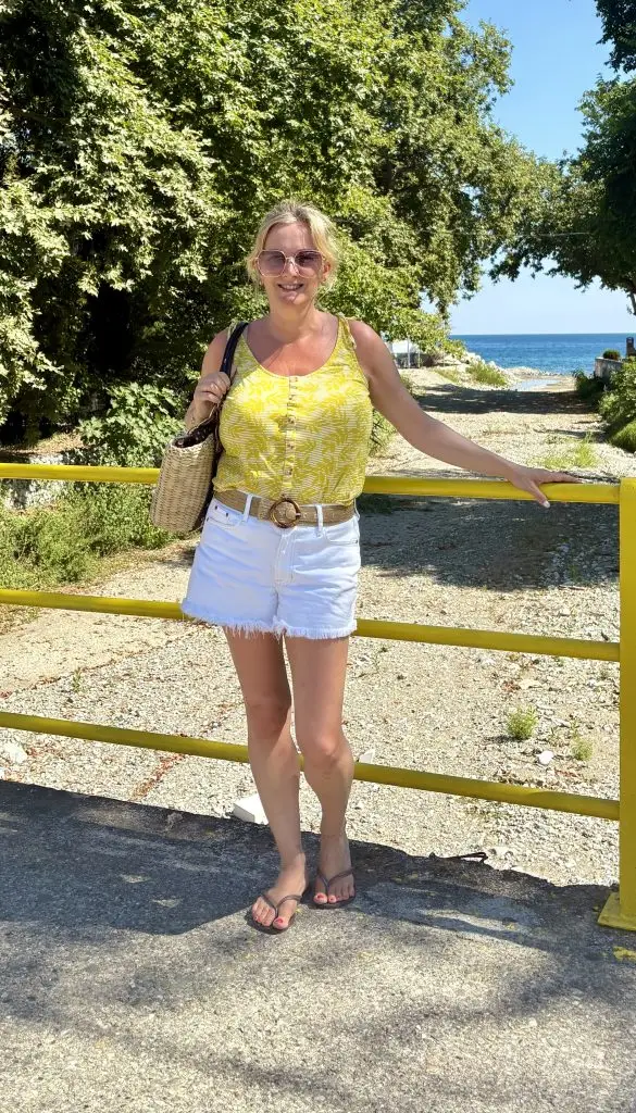Mrs Stylewright wearing white denim shorts and yellow vest top in the sunshine